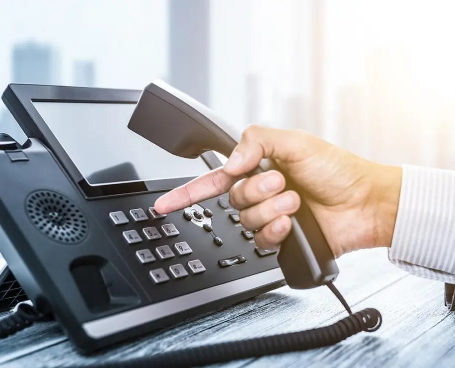 A person's hand holding a telephone receiver