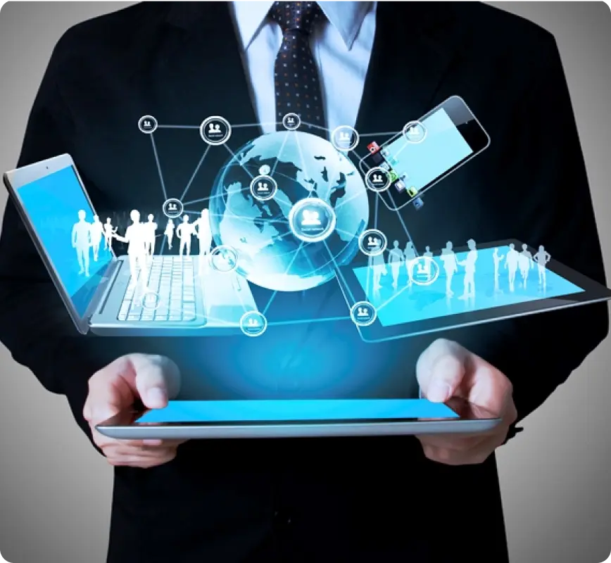 A businessman holding a tablet with digital devices and holographic representations of people and a globe.