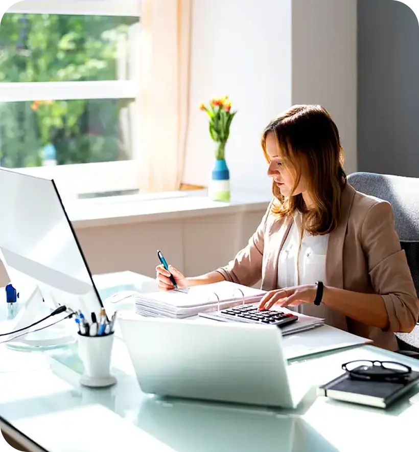 A woman working at a desk with a computer
