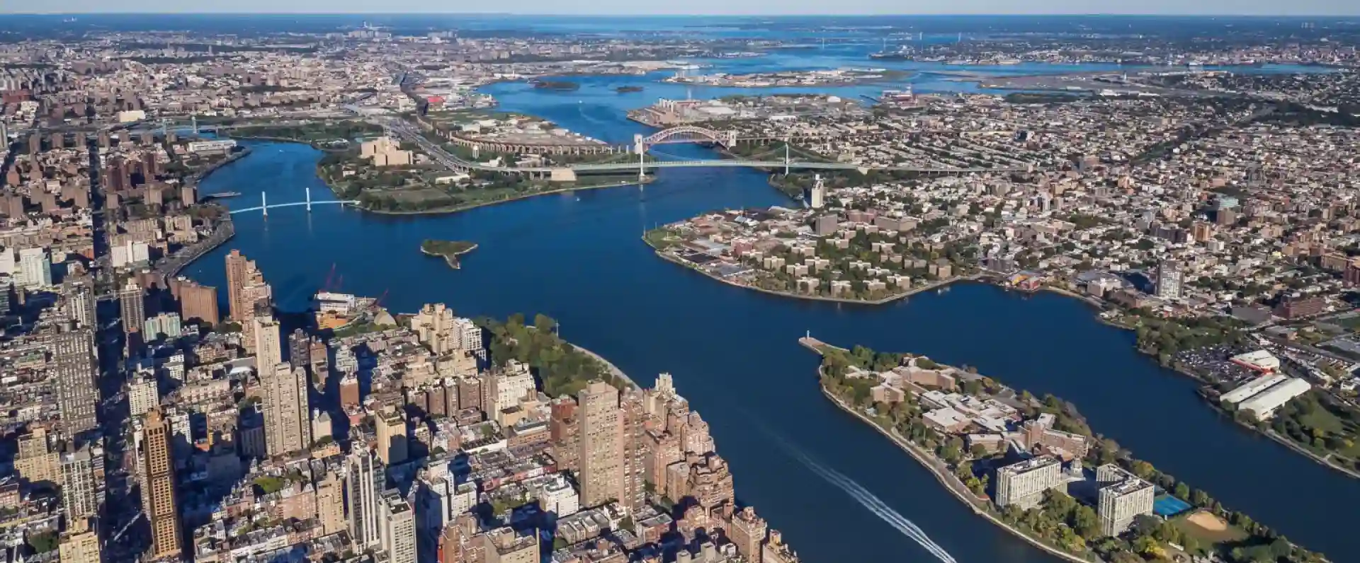 Aerial view of a cityscape with waterways, bridges, and a mix of urban and green landscapes.