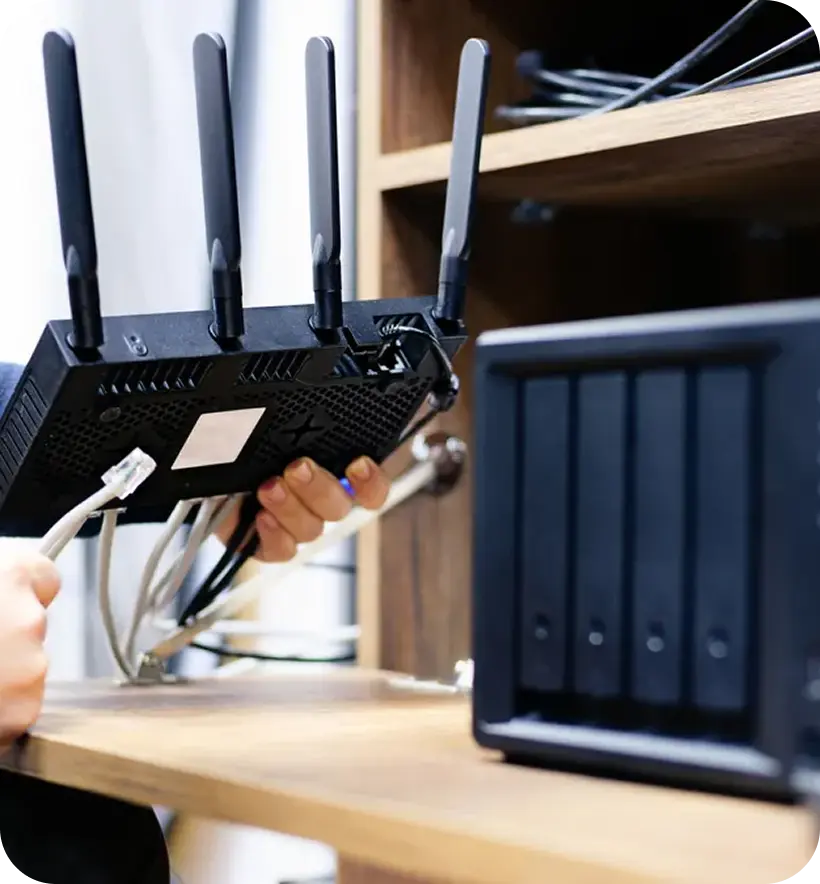 A person holding a wireless router with four antennas