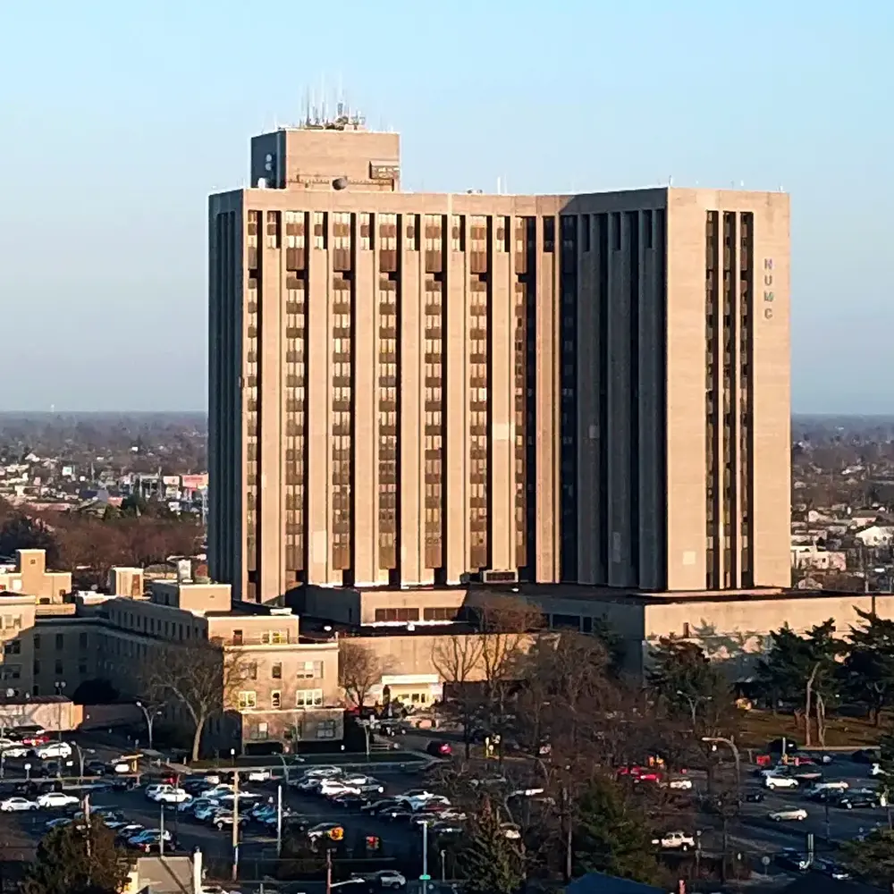 A tall hospital building with a flat roof and multiple floors