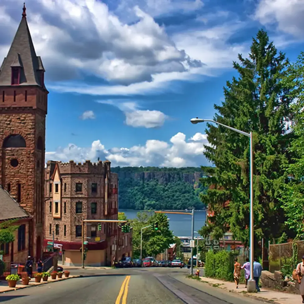 A scenic view of a town featuring a stone building with a steeple
