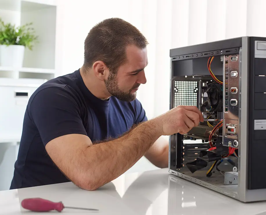 A man is working on the inside of a computer case, installing or repairing components