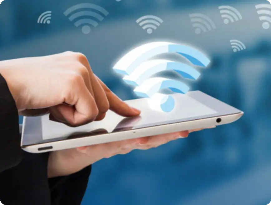 A person using a tablet with a visual representation of Wi-Fi signals above it.