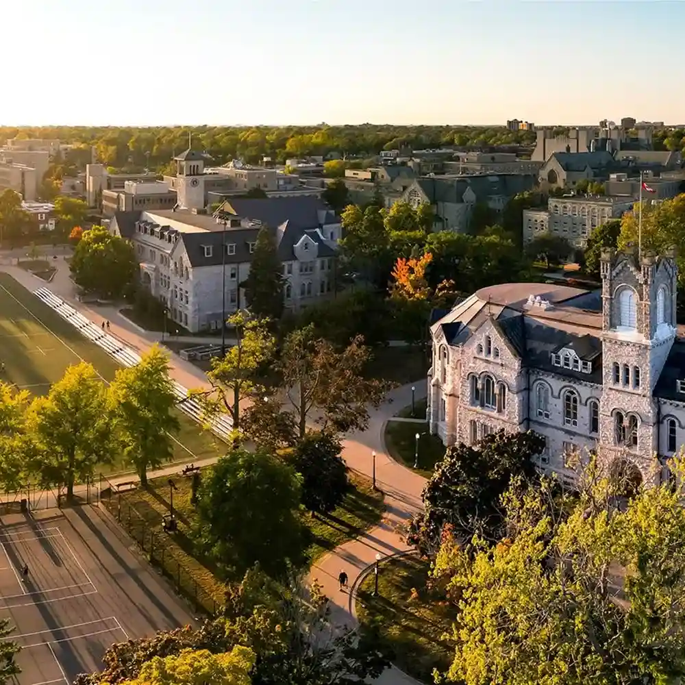 Aerial view of a university campus with green trees, walking paths