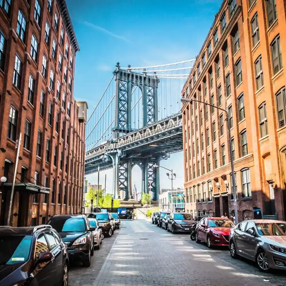 A street view featuring a brick building and parked cars